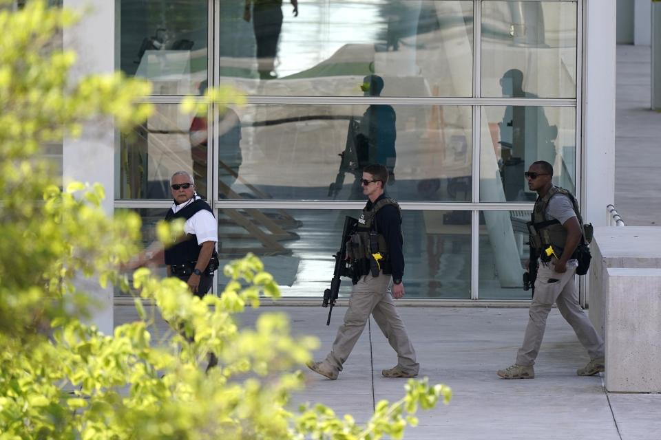 Federal law enforcement personnel patrol outside the Sandra Day O'Connor Federal Courthouse Tuesday, Sept. 15, 2020, in Phoenix. A drive-by shooting wounded a federal court security officer Tuesday outside the courthouse in downtown Phoenix, authorities said. The officer was taken to a hospital and is expected to recover, according to city police and the FBI, which is investigating. (AP Photo/Ross D. Franklin)