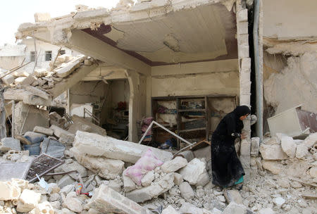 A woman inspects the damage after an airstrike in the rebel held Bab al-Nairab neighborhood of Aleppo, Syria, August 25, 2016. REUTERS/Abdalrhman Ismail