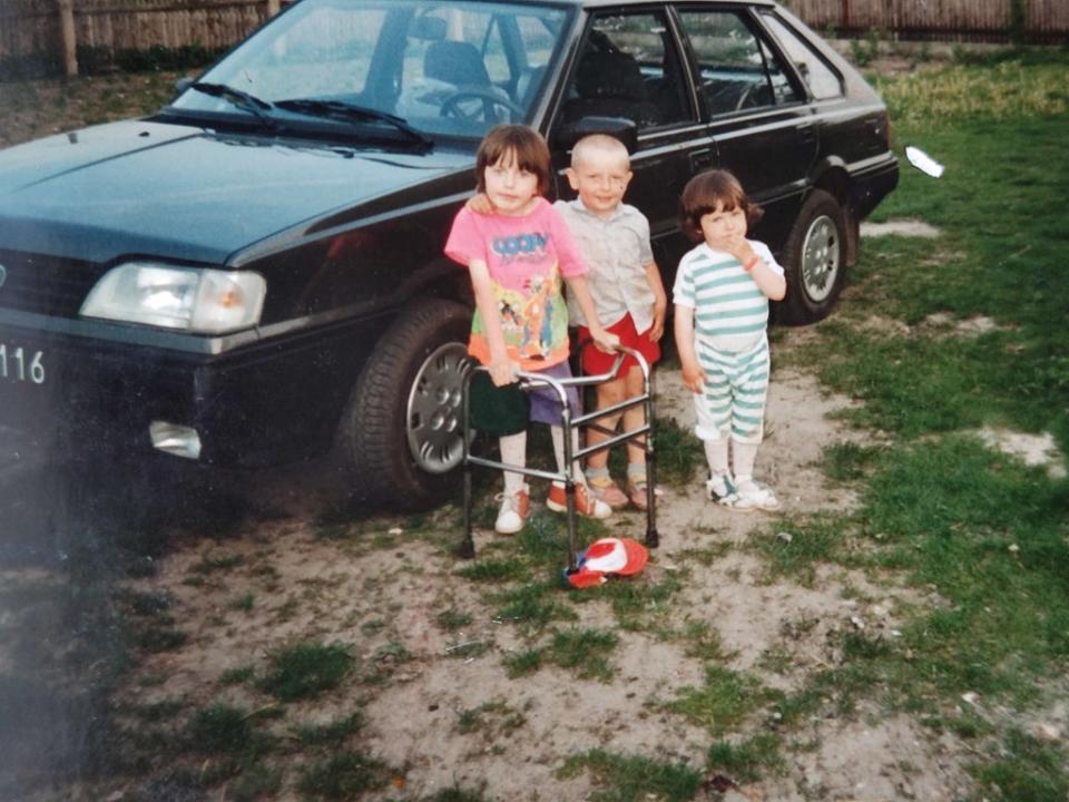 Joanna usando su andadora junto a su primo y su hermana Anna (Collect/PA Real Life)