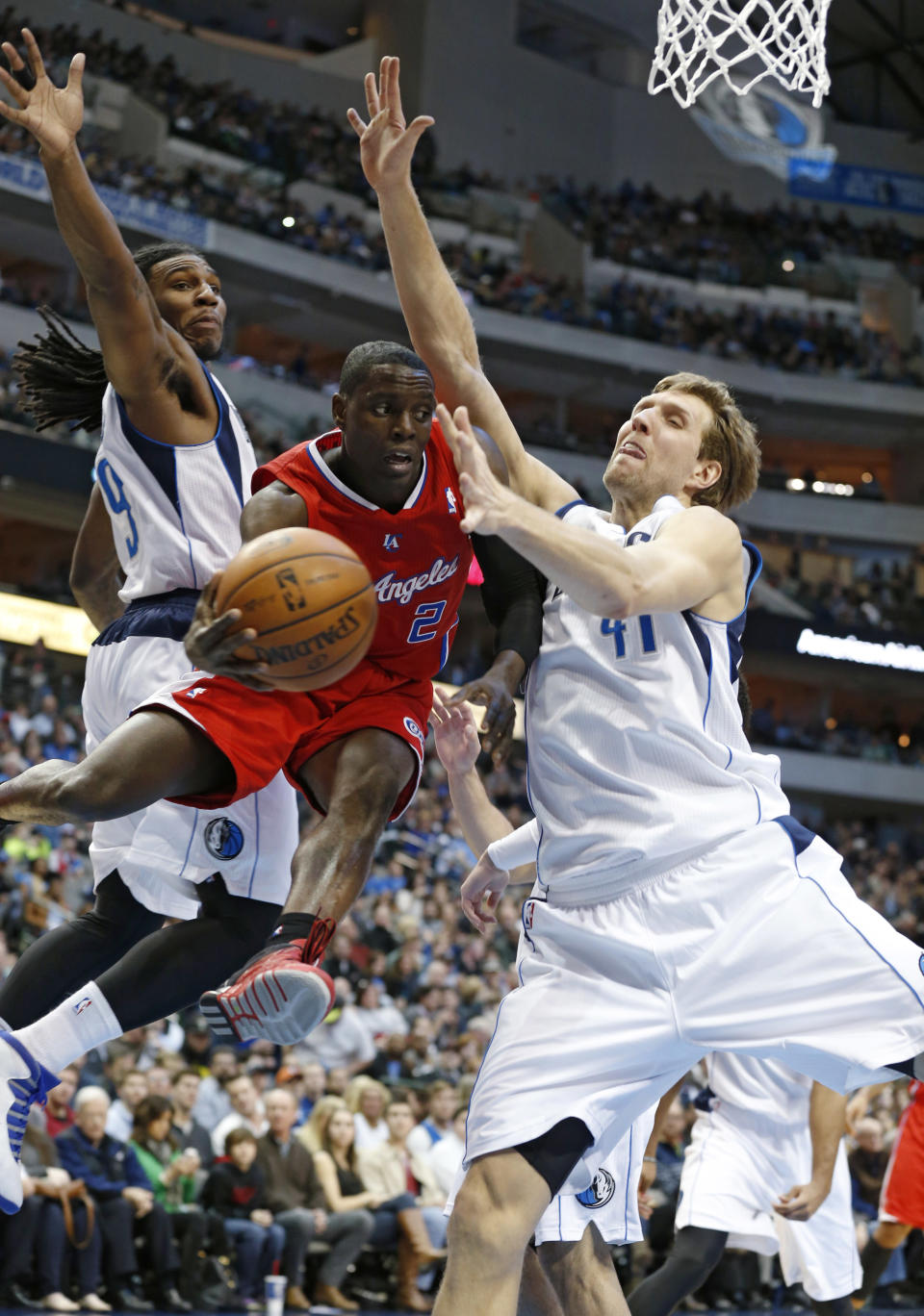Dallas Mavericks forwards Jae Crowder (9) and Dirk Nowitzki (41) defend as Los Angeles Clippers guard Darren Collison passes under the basket during the first half of an NBA basketball game Friday, Jan. 3, 2014, in Dallas. (AP Photo/Sharon Ellman)