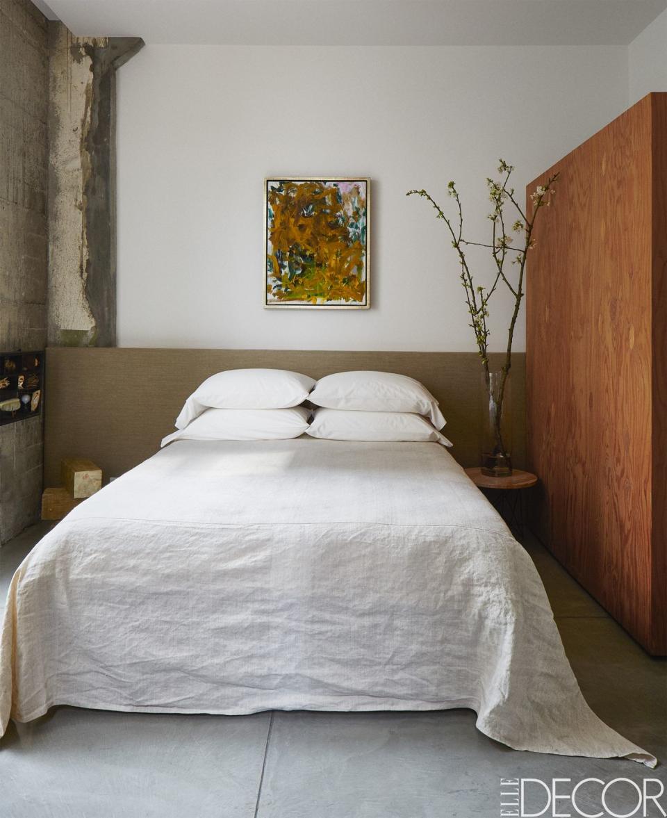 simple boho bedroom with white bedding and a sparse approach to furnishings