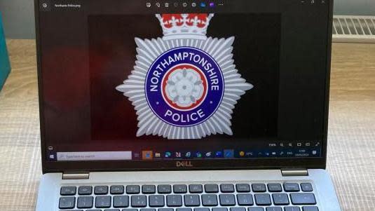 Laptop on a desk showing the Northamptonshire Police logo