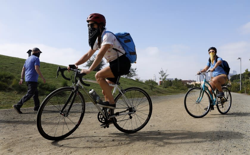 LOS ANGELES-CA-AUGUST 30, 2020: Aimee Gilchrist, 41, founder of Los Angeles Explorer's Club, left, and Marissa López, 45, a professor of English and Chicano studies at UCLA and founder and director of Picturing Mexican America, right, ride through LA State Historic Park during a self-guided bicycle tour they created, on Sunday, August 30, 2020. (Christina House / Los Angeles Times)