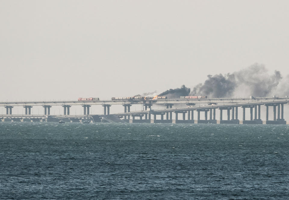 A view shows fuel tanks ablaze and damaged sections of the Kerch bridge in the Kerch Strait, Crimea, October 8, 2022.  REUTERS/Stringer