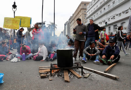 People wait to receive a free meal at a soup kitchen set up on 9 de Julio avenue during a demonstration against the government’s economic measures in Buenos Aires, Argentina September 12, 2018. REUTERS/Marcos Brindicci