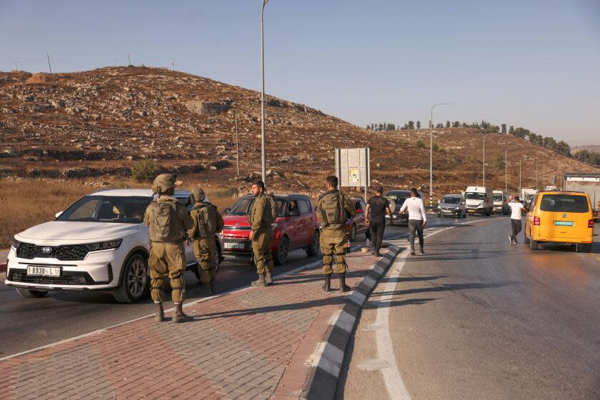 Israeli security forces man a checkpoint at the closed-off southern entrance of Hebron city in the occupied West Bank, on August 22, 2023, near the Israeli settlement of Beit Haggi (background) where a settler killed a day earlier in a shooting attack resided. Israeli forces on August 22 arrested two Palestinians suspected of shooting dead an Israeli settler near Hebron in the occupied West Bank, where violence has surged since early last year. (Photo by HAZEM BADER / AFP) (Photo by HAZEM BADER/AFP via Getty Images)