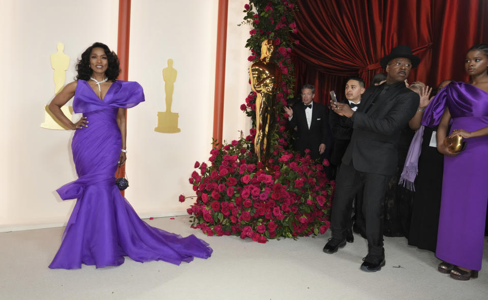 Angela Bassett, left, and Courtney B. Vance, as he takes her picture, arrive at the Oscars on Sunday, March 12, 2023, at the Dolby Theatre in Los Angeles. (Photo by Jordan Strauss/Invision/AP)