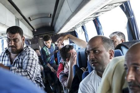 Refugees and migrants are seen on a bus heading to the borders of Greece with Macedonia, following their arrival on the Blue Star Patmos passenger ship, at the port of Piraeus, near Athens, Greece, October 6, 2015. REUTERS/Alkis Konstantinidis