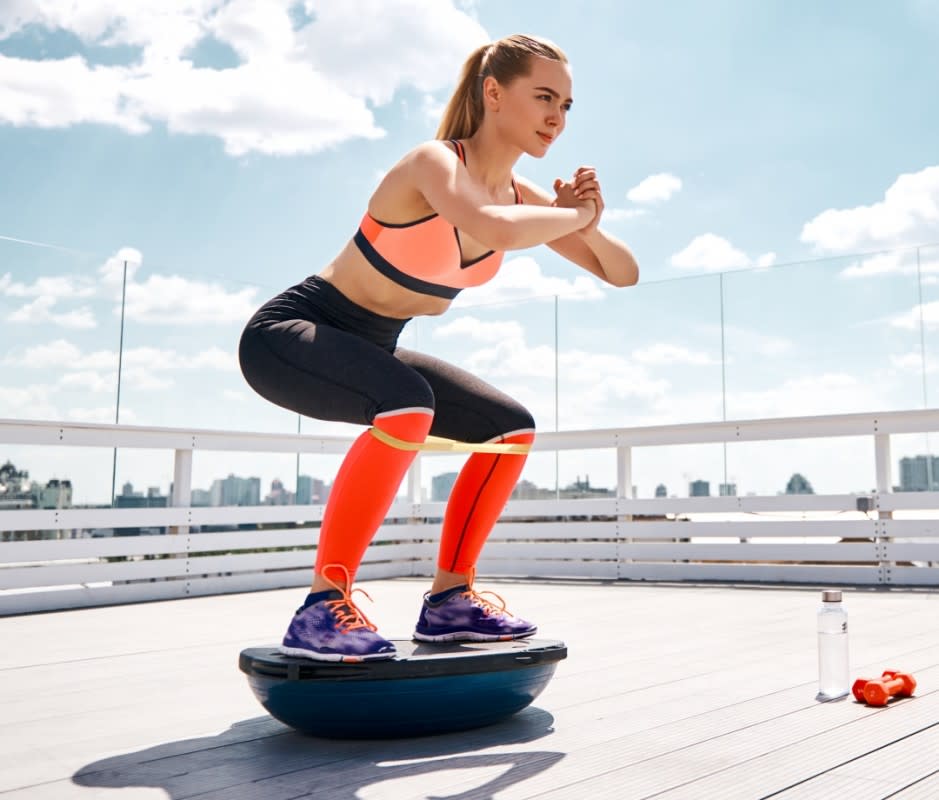 How to Do It:<ol><li>Place a Bosu ball dome-side down.</li><li>Carefully stand on the ball and get your balance.</li><li>Slowly lower into a squat under control.</li><li>Slowly raise yourself up. That's one rep.</li></ol>