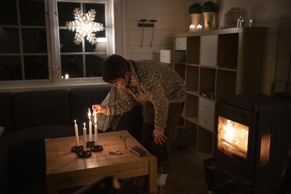 La pastora Siv Limstrand enciende velas en una cabaña de su iglesia luterana en Bolterdalen, Noruega, el lunes 9 de enero de 2023. La cabaña se usa para retiros y grupos de la iglesia. (AP Foto/Daniel Cole)