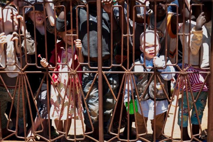 Children behind the gates of the Buhangija orphanage in Shinyanga, the largest of the protectorate, prison-like camps set up in Tanzania to protect children with albinism from murder and attacks.