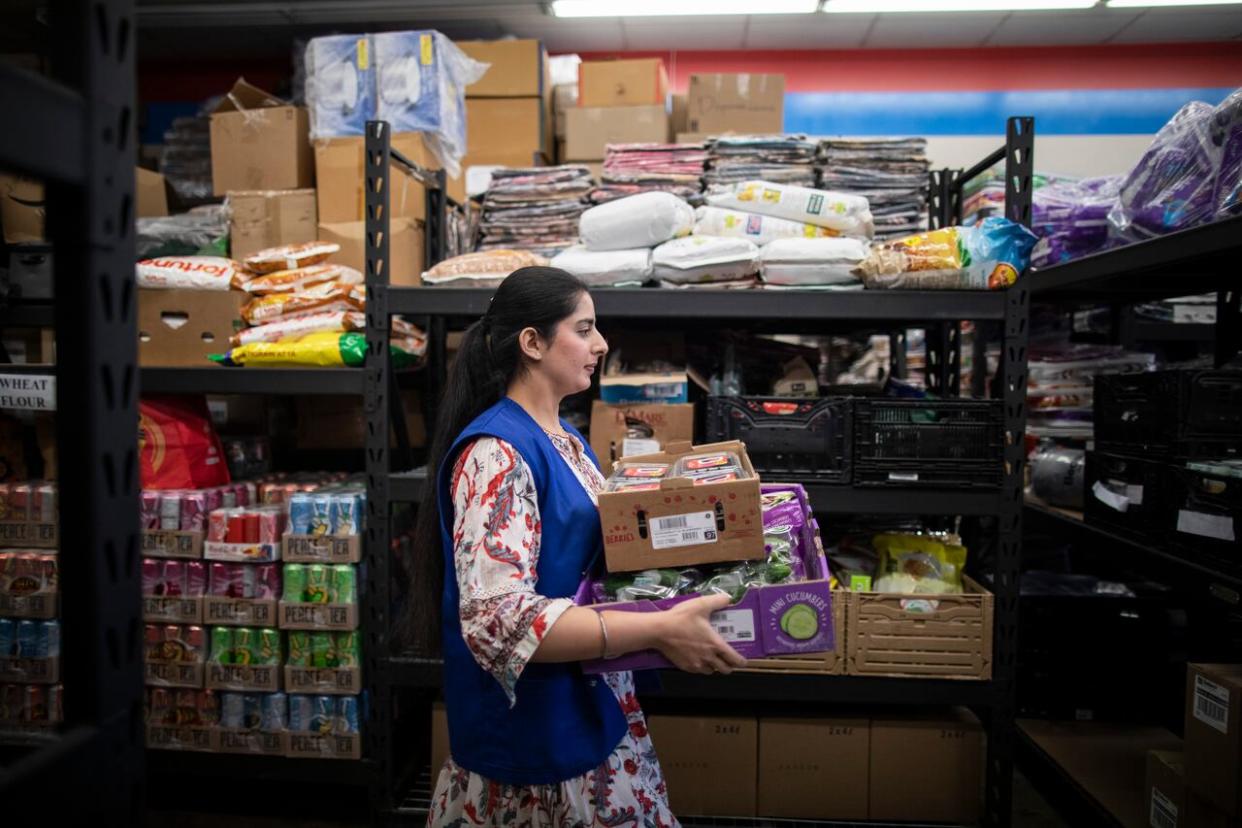 Volunteers pack groceries for people in need  at the Guru Nanak Food Bank in Delta, B.C., on April 19, 2024.   (Ben Nelms/CBC - image credit)