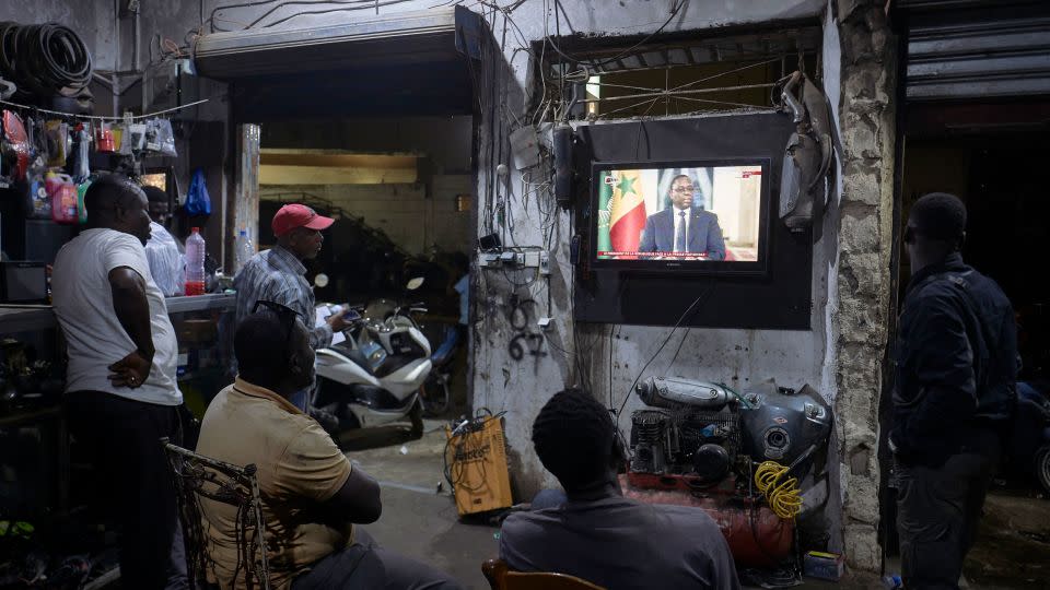 People watch the Senegal's President Macky Sall during a live press conference broadcast on the national television, in the district of Medina in Dakar on February 22, 2024. - Michele Cattani/AFP/Getty Images