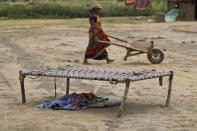 An Indian woman works at a brick kiln as her child sleeps under a cot during lockdown to curb the spread of new coronavirus on the outskirts of Jammu, India, Sunday, May 10, 2020. India's lockdown entered a sixth week on Sunday, though some restrictions have been eased for self-employed people unable to access government support to return to work. (AP Photo/Channi Anand)