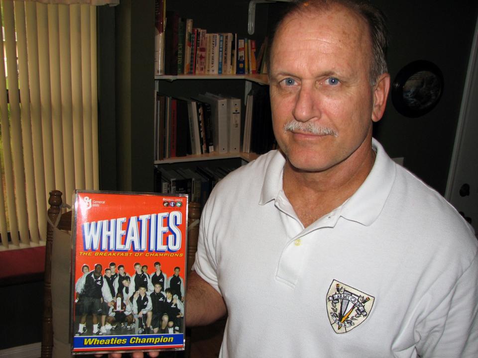 Mariner wrestling coach Dave Phillips at his North Fort Myers home showing off a picture of his 2005 varsity wrestling squad on a mock Wheaties cereal box. Phillips is retiring after 31 years as a teacher and coach in Lee County.