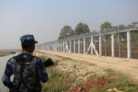 A Myanmar policeman stands outside of a camp set up by Myanmar's Social Welfare, Relief and Resettlement Minister to prepare for the repatriation of displaced Rohingyas, who fled to Bangladesh, outside Maungdaw in the state of Rakhine, Myanmar January 24, 2018. REUTERS/Stringer