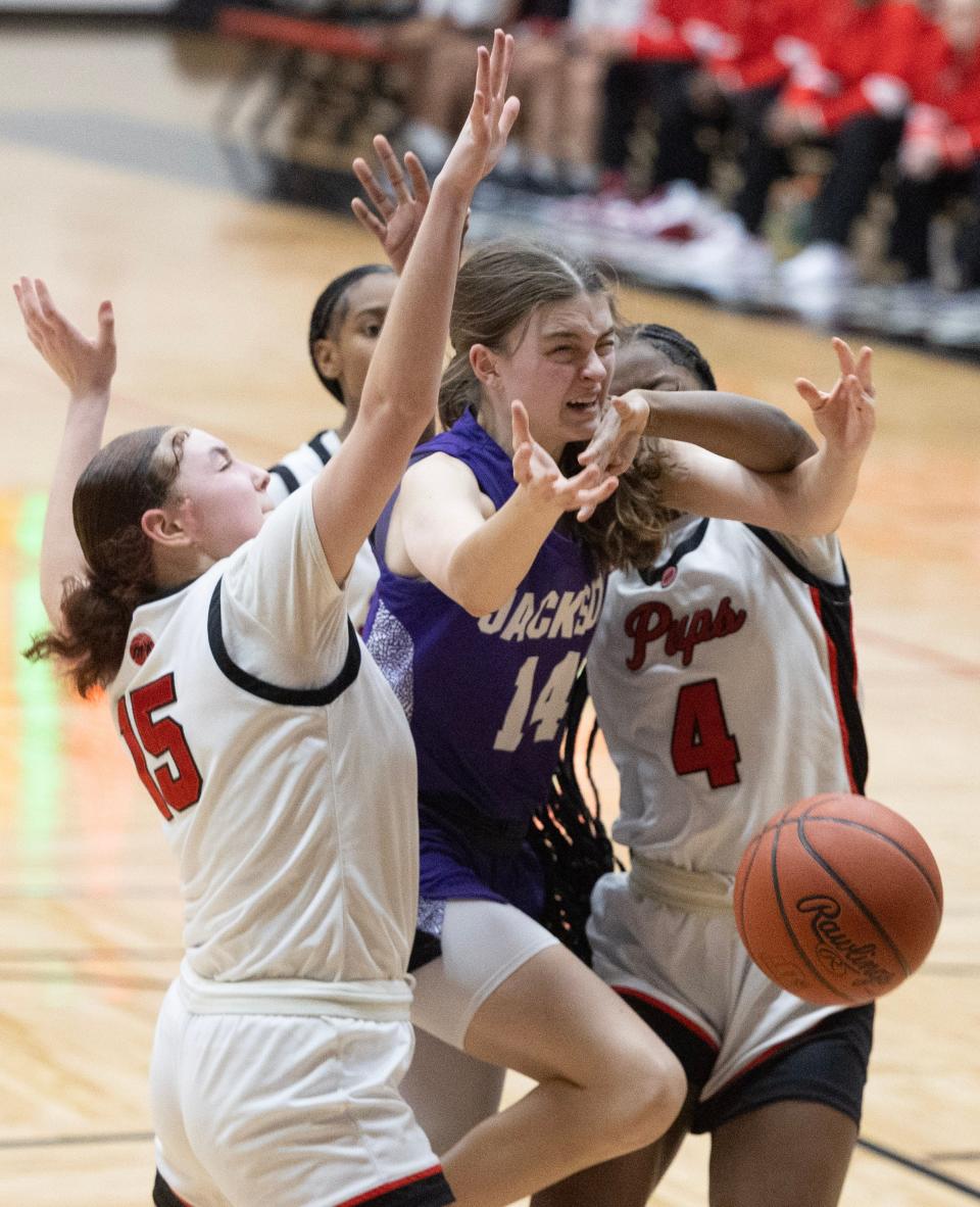 Jackson's Madison Lepley is defended by McKinley's Keziah Herring (4) and Tianni Hilliard (15) in the second half, Wednesday, Jan. 10, 2024.