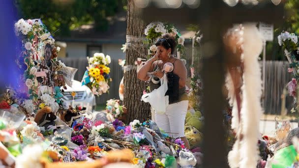 PHOTO: A mourner visits a memorial at Robb Elementary as the Texas Brown Berets prepare to march with family members of those killed and injured in the school shooting at Robb Elementary, Sunday, July 10, 2022, in Uvalde, Texas. (AP Photo/Eric Gay)