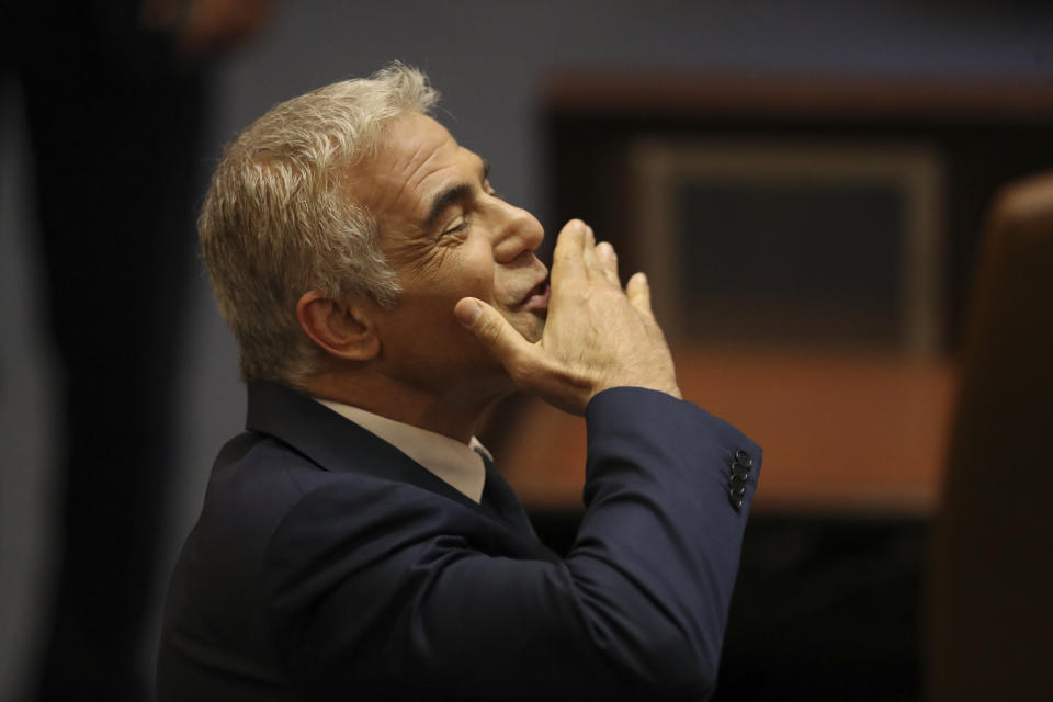 Israeli politician Yair Lapid of the Yesh Atid party sends greetings during a Knesset session in Jerusalem Sunday, June 13, 2021. Bennett is expected later Sunday to be sworn in as the country's new prime minister, ending Prime Minister Benjamin Netanyahu's 12-year rule. (AP Photo/Ariel Schali22