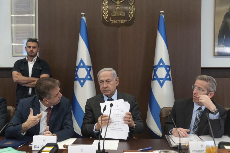Israeli Prime Minister Benjamin Netanyahu, center, Israel's Foreign Minister Eli Cohen, left, and cabinet secretary Yossi Fuchs, right, attend a cabinet meeting at the prime minister's office in Jerusalem, Monday, July 17, 2023. (AP Photo/Ohad Zwigenberg, Pool)