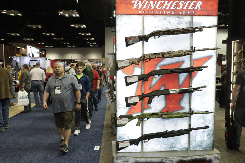 Gun enthusiasts walk through the gun displays in the exhibition hall at the National Rifle Association Annual Meeting in Indianapolis, Saturday, April 27, 2019. (AP Photo/Michael Conroy)