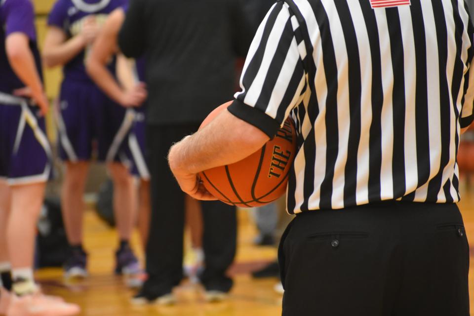 An official looks on during a basketball game.