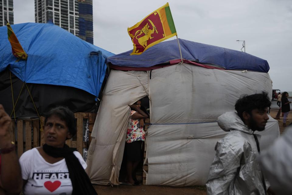 Protesters stand by their tents at the ongoing protest site in Colombo, Sri Lanka, Wednesday, Aug. 3, 2022. Sri Lanka's new president Ranil Wickremesinghe says his government is preparing a national policy roadmap for the next 25 years that aims to cut public debt and turn the country into a competitive export economy as it seeks a way out of its worst economic disaster.(AP Photo/Eranga Jayawardena)