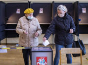 Local residents, wearing face masks to protect against coronavirus, cast their ballots at a polling station during the second round of a parliamentary election in Vilnius, Lithuania, Sunday, Oct. 25, 2020. Polls opened Sunday for the run-off of national election in Lithuania, where the vote is expected to bring about a change of government following the first round, held on Oct. 11, which gave the three opposition, center-right parties a combined lead. (AP Photo/Mindaugas Kulbis)