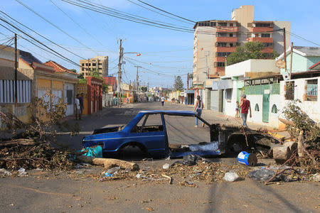 A wrecked car and others debris, used as a barricade, are seen on an empty street during a strike called to protest against Venezuelan President Nicolas Maduro's government in Maracaibo, Venezuela July 26, 2017. REUTERS/Isaac Urrutia