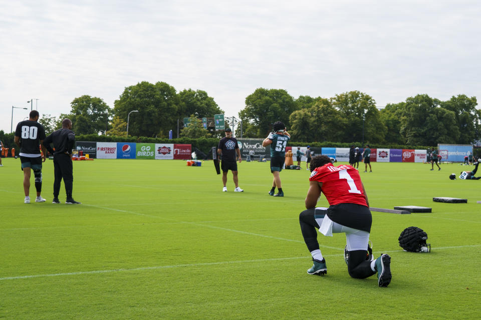 Philadelphia Eagles' Jalen Hurts, right, kneels before taking the field during the NFL football team's training camp, Wednesday, July 27, 2022, in Philadelphia. (AP Photo/Chris Szagola)