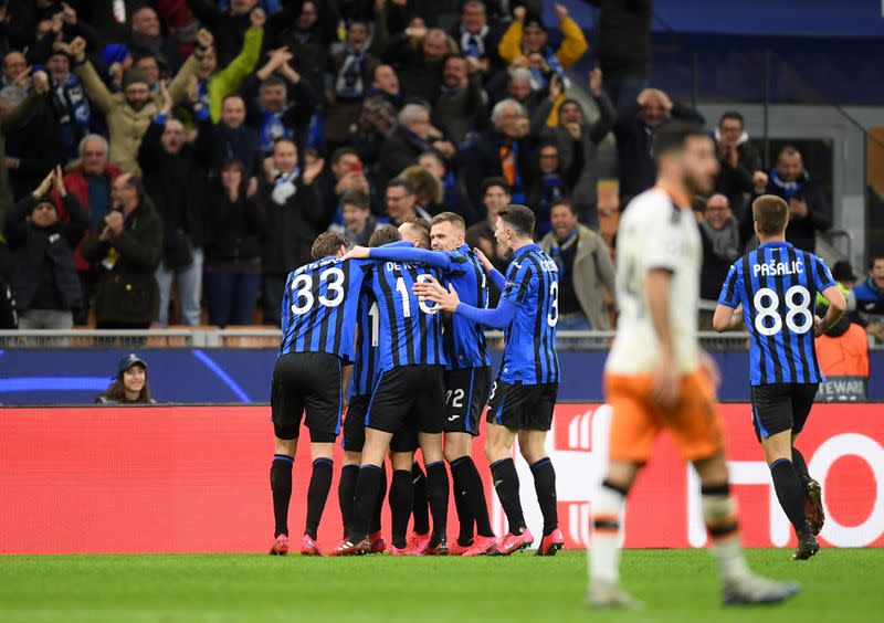 Jugadores del Atalanta celbran el tercer gol del equipo en la goleada 4-1 sobre el Valencia por la Liga de Campeones, en Milán, Italia