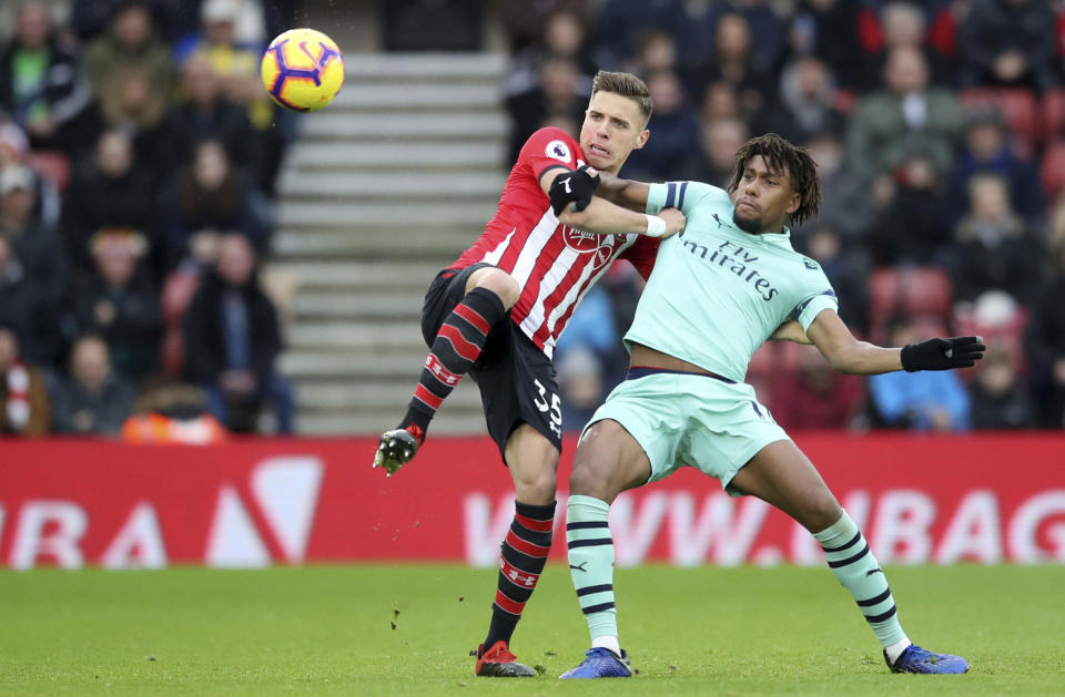 Arsenal's Alex Iwobi, left, and Southampton's Jan Bednarek in action during their English Premier League soccer match at St Mary's Stadium in Southampton, England, Sunday Dec. 16, 2018. (Adam Davy/PA via AP)