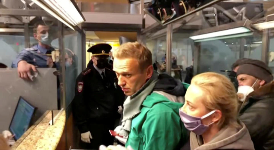 A still image taken from video footage shows law enforcement officers speaking with Navalny at Moscow’s Sheremetyevo Airport.