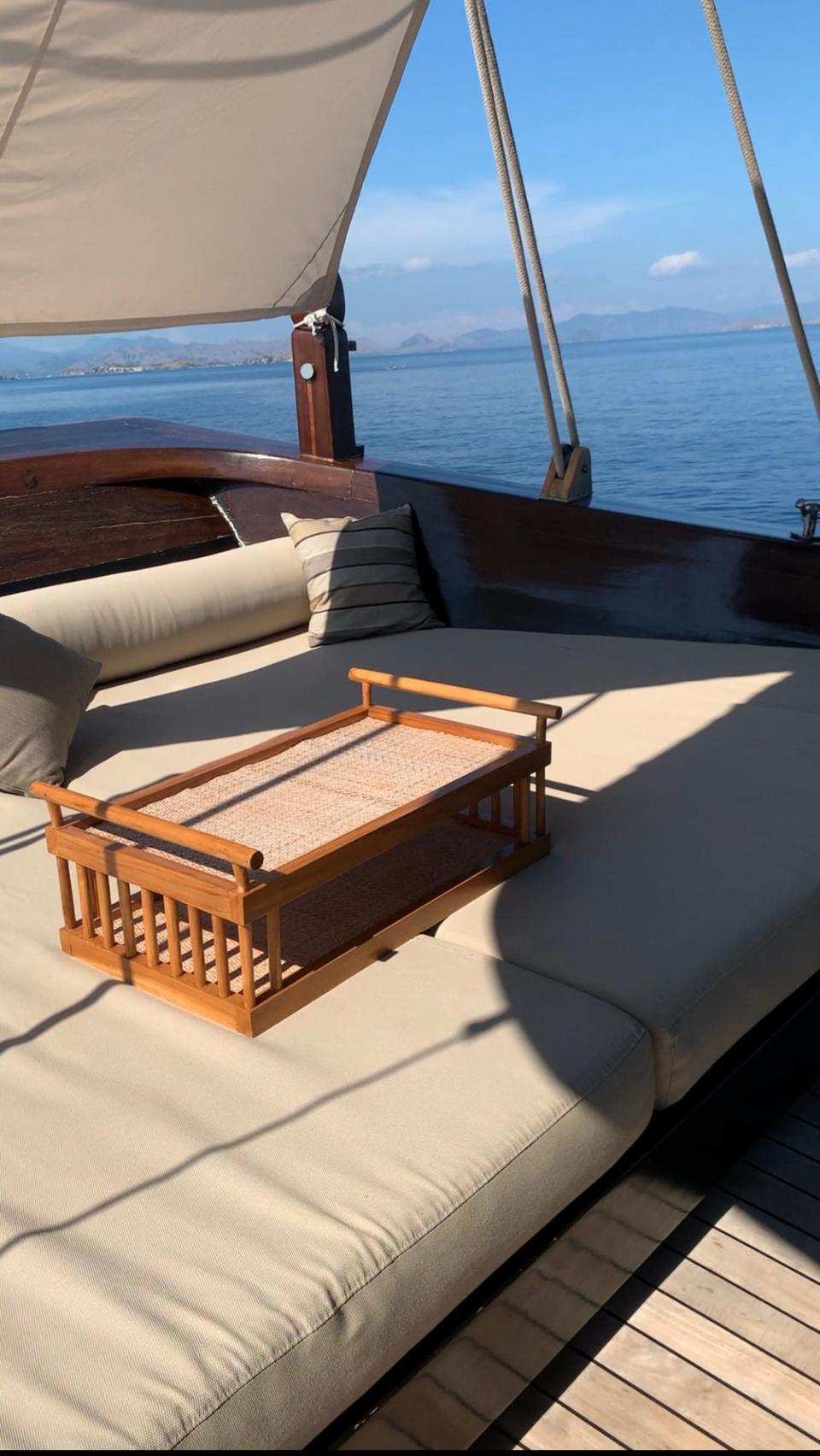 An outdoor lounge area on a sailing ship with plush seating.