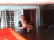 PAWS rescuer John Tangkeko rescues a dog from a flooded home