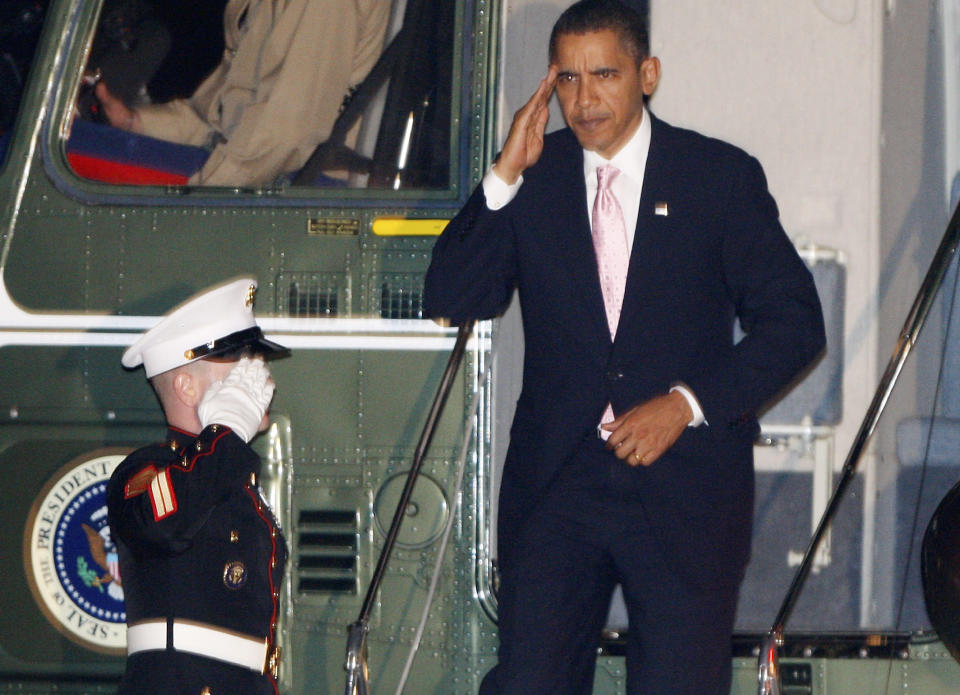 President Barack Obama returns a salute as he steps off Marine One helicopter on the South Lawn of the White House in Washington, Friday night, Oct. 23, 2009, the day he declared the swine flu outbreak a national emergency. (AP Photo/Charles Dharapak)