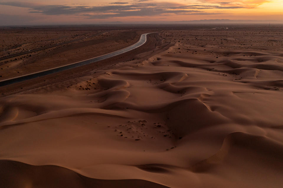 FELICITY, CALIFORNIA - SEPTEMBER 28: In an aerial view, the All-American Canal conveys water through the Imperial Sand Dunes of California's Colorado Desert, a few miles north of the U.S.-Mexico border, on September 28, 2022 near Felicity, California. The 80-mile long canal carries water from the Colorado River to supply nine Southern California cities and 500,000 acres of farmland in the Imperial Valley where a few hundred farms draw more water from the Colorado River than the states of Arizona and Nevada combined. As drought shrinks the Colorado River to historic low levels and with states that rely on it facing major water shortages, pressure is building on the growers to give up some of the water rights they had inherited long ago. The Imperial Sand Dunes are the remnants of the beach sands of ancient Lake Cahuilla, the basin of which is where the dying Salton Sea is located. The federal government has proposed an unprecedented plan to cut back on water supplies for Arizona, Nevada and California, where millions of people rely on its water and power, as climate change-driven drought continues to lower water levels at the biggest reservoirs in the nation, lakes Mead and Powell, to historic low capacities.  (Photo by David McNew/Getty Images)