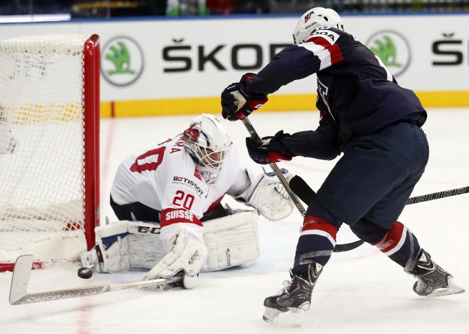 Switzerland goaltender Reto Berra makes a save in front of USA forward Tim Stapleton during the Group B preliminary round match between Switzerland and USA at the Ice Hockey World Championship in Minsk, Belarus, Saturday, May 10, 2014. (AP Photo/Darko Bandic)