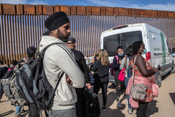 PHOTO: In this Dec. 9, 2021, file photo, immigrants from India and Haiti wait with others to be transported to a U.S. Border Patrol processing center in Yuma, Ariz. (John Moore/Getty Images, FILE)