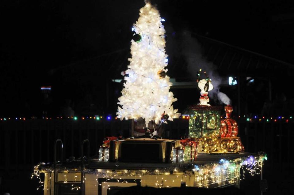 A boat decorated with a Christmas tree, Snoopy and a train dazzles a crowd Saturday at the Lights on the Lake Boat Parade in Lake Wylie.