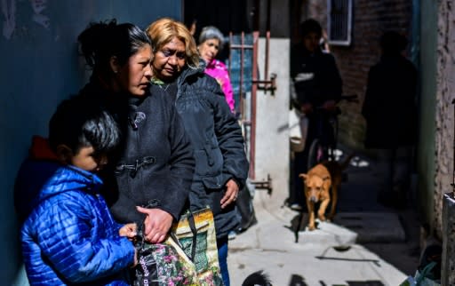 People wait for food outside Avia's house, where a soup kitchen feeds at least 200 people a day