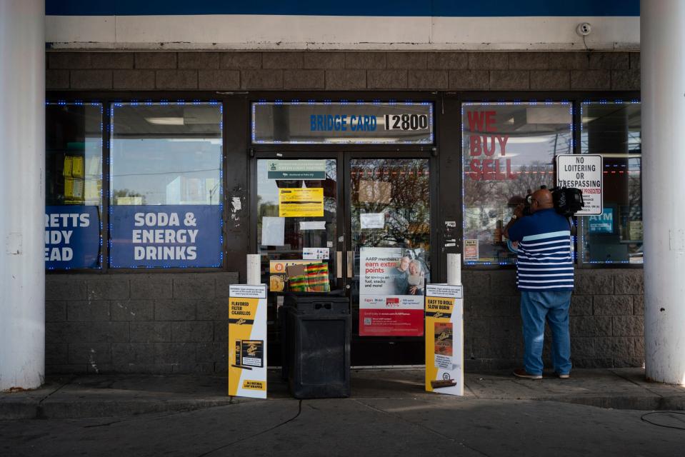 A television cameramen films through the window of a Mobil gas station that remains shut down days after a triple-shooting on West McNichols Road near the John C. Lodge Freeway in Detroit on May 10, 2023.