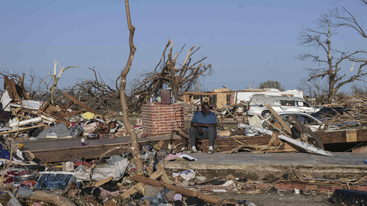  A man sits among the wreckage from a tornado that went through western Mississippi.  