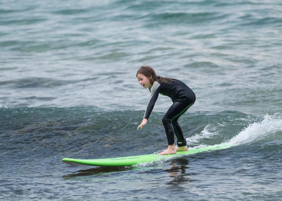 <p>Youngest daughter Faith showed no fear and was all smiles while she caught a wave into mum and dad.</p>