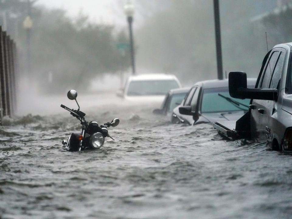 motorcycle and line of cars poke out above floodwaters