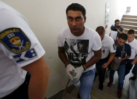 Police escort suspects in the deaths of 71 refugees found in a truck on an Austrian motorway, in Kecskemet, Hungary, August 29, 2015. REUTERS/Laszlo Balogh