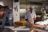 A worker cuts meat at a butcher shop in Manhattan, New York City