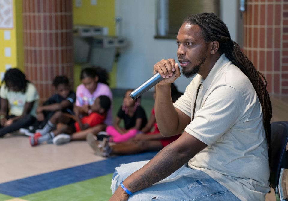 Site coordinator Marcus Washington, right, talks Wednesday to children during the Central Gulf Coast Children's Defense Fund Freedom School's morning Harambee — which means "all pull together" in Swahili — at the Global Learning Academy in Pensacola.