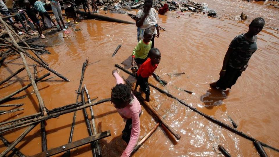 Residents wade through floodwaters after the Nairobi River burst its banks and destroyed their homes in the Mathare Valley settlement in Nairobi, Kenya, April 24, 2024