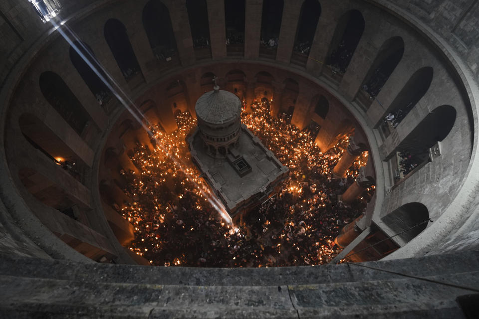 Christian pilgrims hold candles during the Holy Fire ceremony, a day before Easter, at the Church of the Holy Sepulcher, where many Christians believe Jesus was crucified, buried and resurrected, in Jerusalem's Old City, Saturday, April 15, 2023. (AP Photo/Tsafrir Abayov)